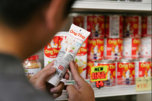 A person holding a tube of food  Description automatically generated